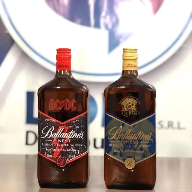 Botellas de Ballantine's edición AC/DC y Queen delante del banner de Lider